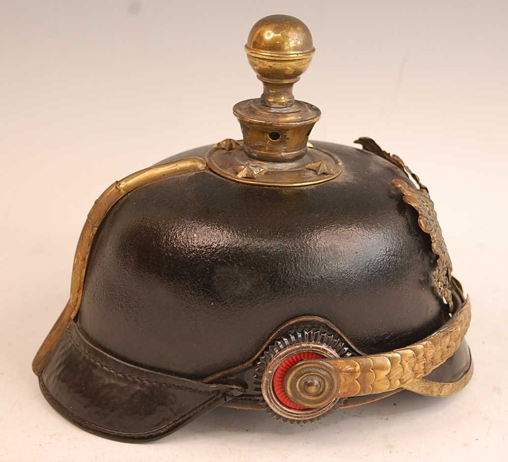 A Prussian pickelhaube, the leather skull with brass ball top and eagle plate, flanked by state - Image 6 of 9