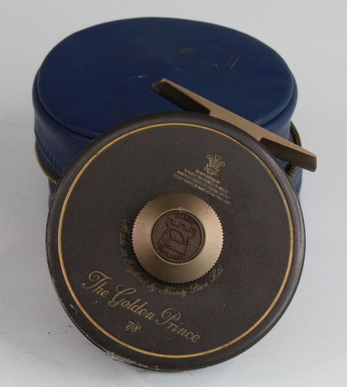 A Hardy The Golden Prince 7/8 3 1/4" centre pin fly reel, in H of H blue leather pouch.