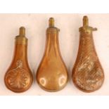 A 19th century copper powder flask, of pear shape with embossed shell decoration, the brass nozzle