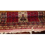 A Turkish woollen red ground prayer rug, having flatweave Kilim ends, 97 x 180cm