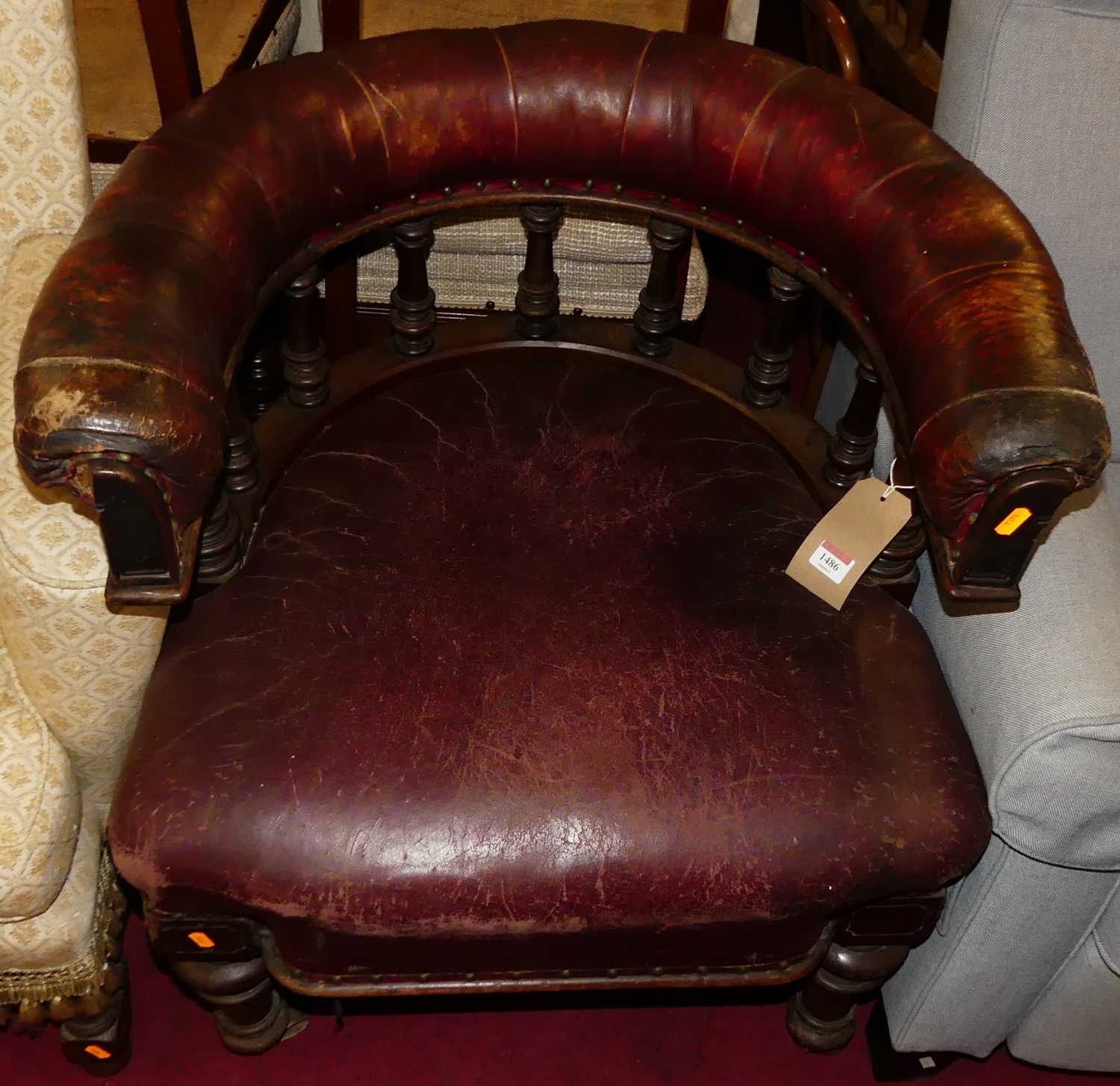 A mid-Victorian mahogany and tan leather upholstered tub desk chair, having ring turned supports,