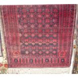 A Persian woollen red ground Bokhara rug, the repeating central ground within tramline borders,