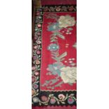 A Turkish red ground woollen rug, with all over stylised floral decoration within single trailing