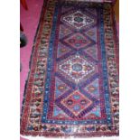 A Persian woollen blue ground Turkoman rug, the central lozenge ground within trailing borders,