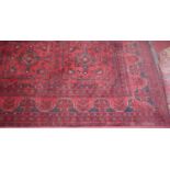 A Persian woollen red ground Bokhara rug, 235 x 174cm