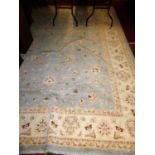 A Pakistani hand knotted pale blue ground woollen rug, typically floral decorated, 365 x