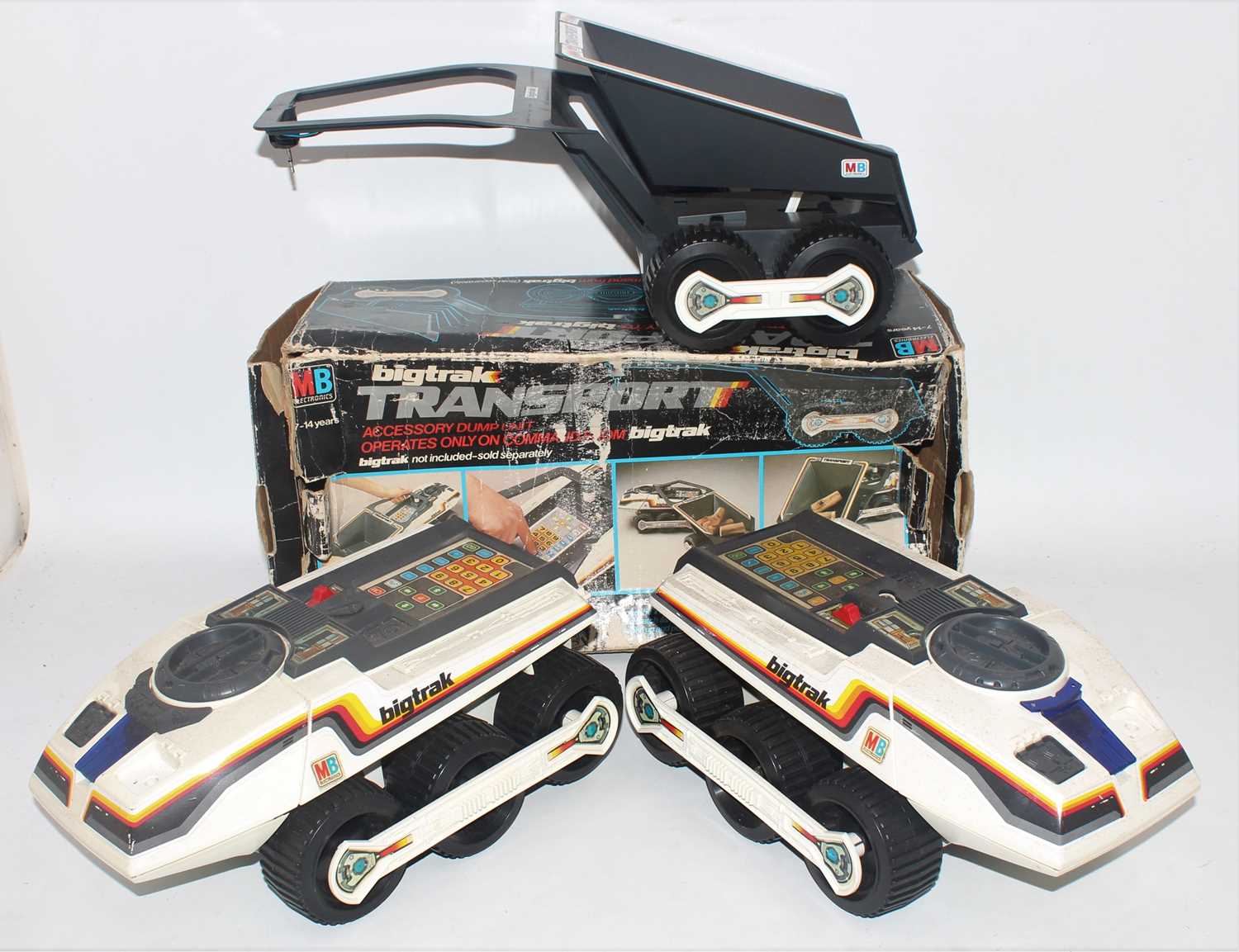 A collection of MB Electronics Bigtrak vehicles, one housed in the original box the others both