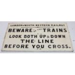 A London and North Western Railway 'Beware of the Trains' cast-iron notice, finished in black on