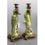 A pair of continental porcelain and brass mounted table candlesticks, each in the form of a