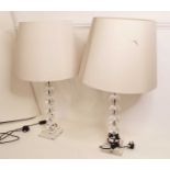 A pair of modern glass table lamps, of beaded form, each on a stepped plinth, with cream shades, h.