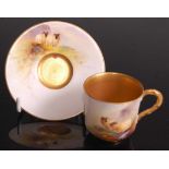 A Royal Worcester porcelain miniature cabinet cup and saucer, painted in polychrome enamels with two