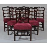 A set of six George III mahogany dining chairs, having pierced wavy ladderbacks and stuffover seats,