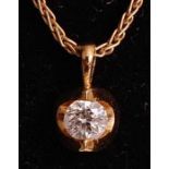 An 18ct yellow gold abstract diamond pendant, having a round brilliant cut diamond in a semi-tension