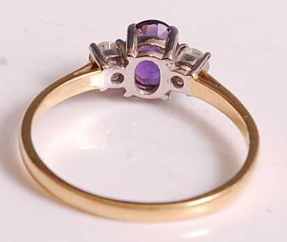 An 18ct yellow and white gold, amethyst and diamond three-stone ring, comprising a centre oval - Image 3 of 7