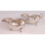 A near-pair of George V silver sauce-boats, of plain form with stylised S-scroll handles and egg and