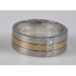 A yellow and white metal satin finish three strand ring, having three Princess cut diamonds