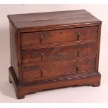 An antique oak chest, of small proportions, having a two plank top and three long drawers, w.72cm,