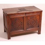 A 17th century joined oak two-panel coffer, the two plank top blind carved with a portrait of Oliver