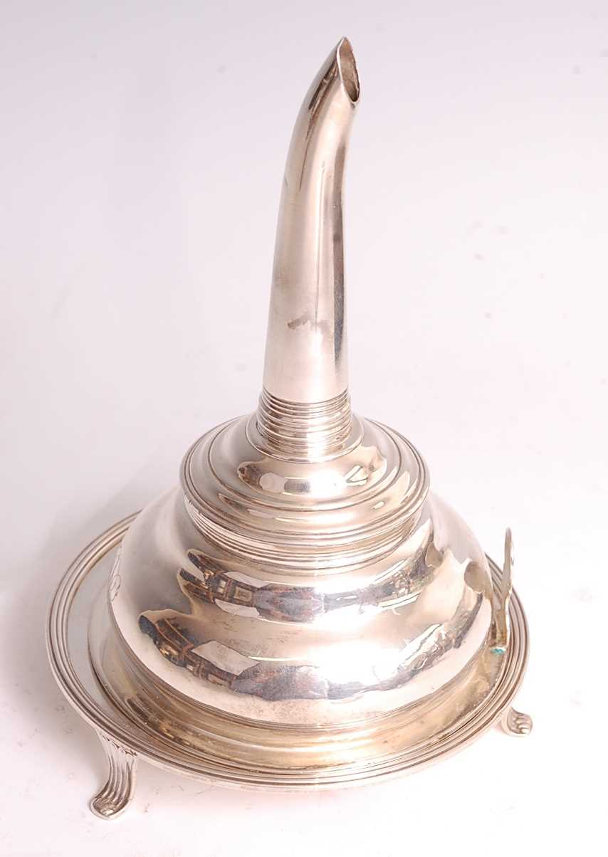 A George III silver wine funnel on stand, the strainer bowl of typical reeded form with shaped tang,