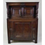 A late 17th century joined oak court cupboard, the upper section having monogrammed frieze and