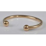 A 9ct yellow gold torque bangle, width 4.7mm, diameter 62 x 45mm, gross weight 32.6g, hallmarked