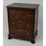 An early 18th century joined oak chest, of three long drawers, each on channel runners and with