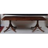 A mahogany twin pedestal dining table, the 19th century top with later ebony inlays, raised on a