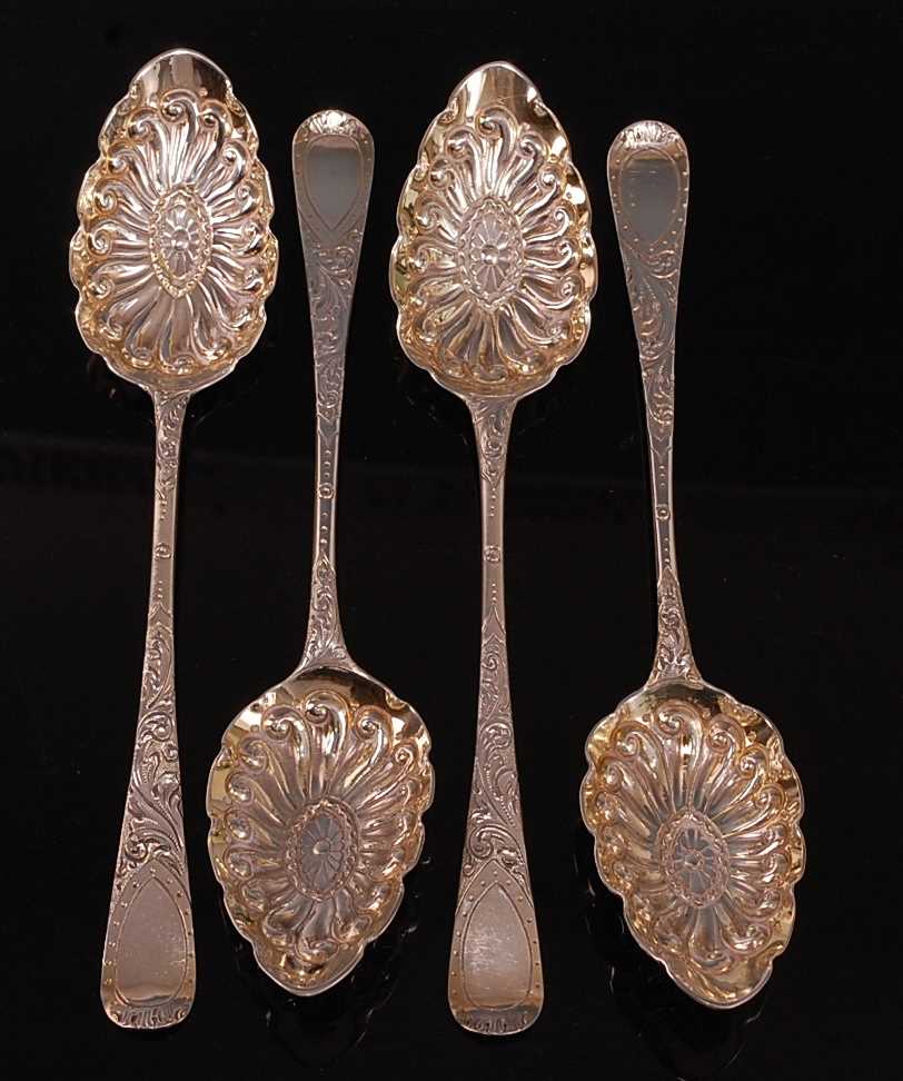 A matched set of four George III silver berry spoons, in the Hanoverian pattern, the gilt-washed