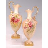 A pair of Edwardian Royal Worcester porcelain pedestal ewers, hand-painted floral decoration on a