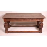 An antique oak refectory table, in the Elizabethan style, having a two plank top, blind carved