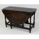 A circa 1700 joined oak gateleg table, having oval fall leaves and on ring turned and square cut end