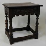 An early 18th century oak joint stool, the one-piece top with a chip carved edge a leaf carved