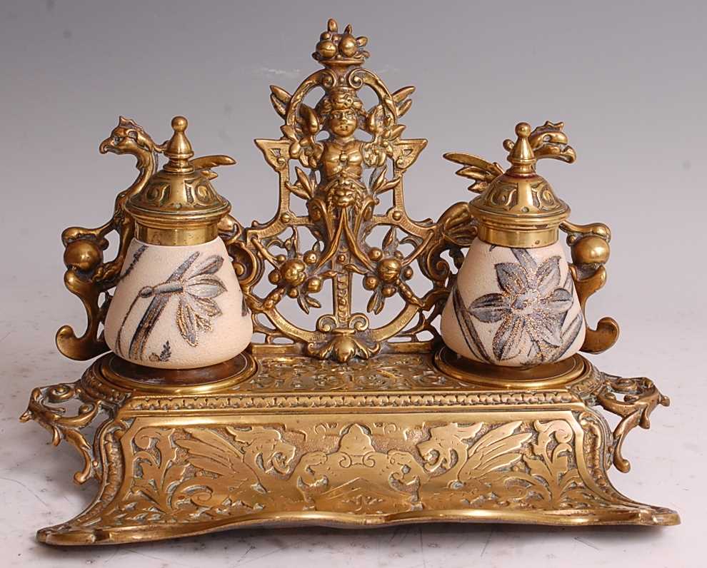 A late Victorian heavy gilt brass desk stand, having scoop pen tray and twin inkwells, the brass