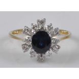 A yellow and white metal, sapphire and diamond oval cluster ring, featuring a centre oval faceted