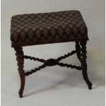A Victorian rosewood footstool, having a woolwork stuffover seat and raised on spiral turned