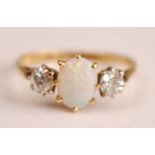 A yellow and white metal, opal and diamond three-stone ring, having a centre oval white opal