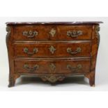 An 18th century French provincial walnut commode, of serpentine outline, having a veined rouge