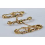 A set of three yellow metal, emerald and seed pearl bar brooches, joined together with 1mm trace