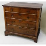 An early 18th century oak chest, of two short and three long graduated drawers, each on channel