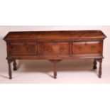 An 18th century oak and fruitwood dresser base, the two plank top having cleated ends and moulded