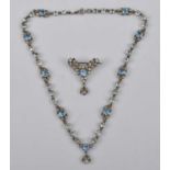 An Edwardian white metal paste set necklace and brooch, the necklace comprising floral shaped