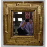 An 18th-century giltwood and gesso wall mirror, having raised and proud moulded corners, replacement