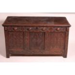A late 17th century joined oak coffer, having a planked top over a three panel front, with all-