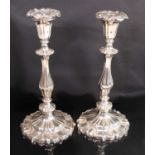 A pair of early Victorian silver table candlesticks, having shaped circular loaded bases with chased