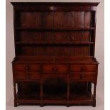 An 18th century oak dresser, the upper section having a two-tier plate rack with ironmongery to each