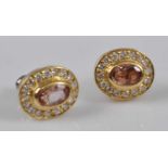A pair of yellow metal, topaz and diamond oval cluster earrings, each with a centre oval pink