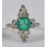 A white metal Art Deco emerald and diamond cluster ring, featuring a centre octagonal cut emerald