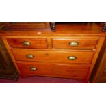 A stained pine low chest of two short over two long drawers (one handle requires re-attachment),