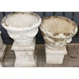 A pair of reconstituted stone circular garden planters in the Adam style, of tapering form, each