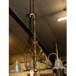 An Art Nouveau turned brass hanging three-branch ceiling light, having shaped frosted glass